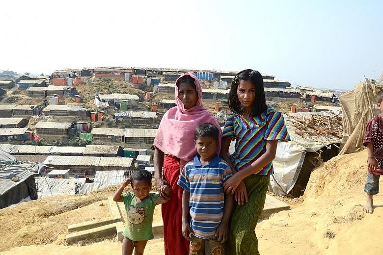 The hills in southern Cox's Bazar have been stripped of foliage and packed instead with thousands of bamboo-framed, tarpaulin-lined huts. Left: Ms Khursida Begum, 20, a Rohingya refugee with two children. She is one of the female volunteers engaged b