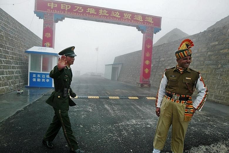A Chinese soldier and an Indian soldier at the Nathu La border crossing between India and China. US geopolitical intelligence platform and publisher Stratfor, in an assessment of recent satellite imagery of two Chinese and two Indian airbases, said a