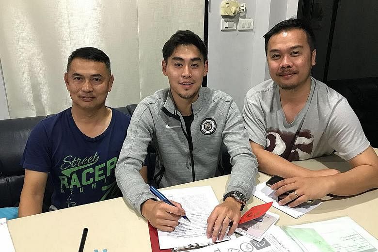 Singapore winger Gabriel Quak puts pen to paper on his one-season deal with Thai League 1 side Navy in Chonburi last Friday, watched by the club's general manager Niwat Jitpoolphol.