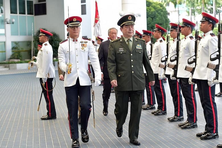 Top: Chinese Defence Minister Chang Wanquan inspecting a guard of honour with Defence Minister Ng Eng Hen (behind Gen Chang) at Mindef yesterday. Above: General David Goldfein (left), the US Air Force Chief of Staff, met Second Minister for Defence O