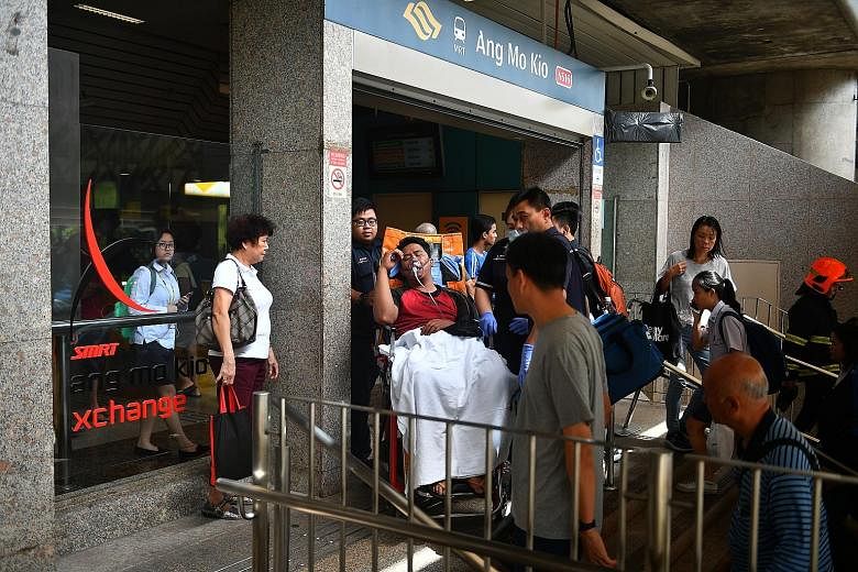 An SMRT maintenance worker being taken to hospital for smoke inhalation after smoke emanated from a faulty escalator inside Ang Mo Kio MRT station yesterday. A section of the station was cordoned off and the linkway to nearby mall AMK Hub was closed.