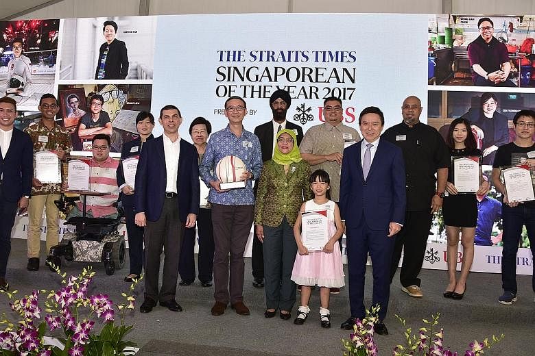 President Halimah, accompanied by Mr Fernandez, greeting past finalist John Shu, a mechanic who gave $6,000 to a single mother to pursue her education. With them are Singaporean of the Year 2015 award winner Noriza A. Mansor (in green), who won heart