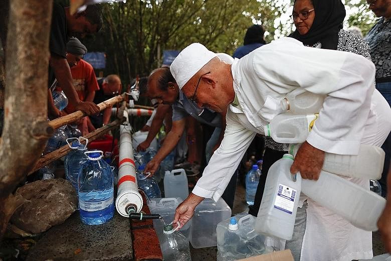 Residents of Cape Town collecting drinking water from a mountain spring collection point on Jan 31.