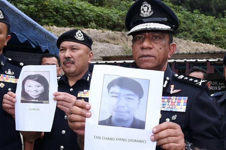 Johor police chief Mohd Khalil Kader Mohd (at right) and his deputy Mohd Kamarudin Md Din with photos of the two missing Singaporeans, Mr Dominick Tan Chang Xiang and Ms Lum Jie, at the search and rescue operations centre yesterday.