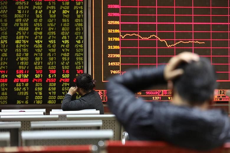 Chinese investors watching the market at a securities brokerage house in Beijing yesterday. The tremors in Singapore also took their cue from a deepening sell-off in China, worsened by tighter credit rules and the speculative nature of the market.