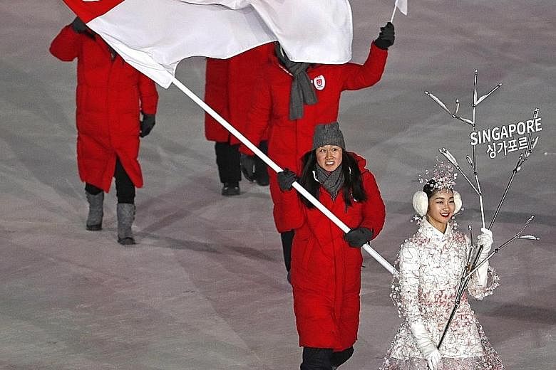 Cheyenne Goh carrying the Singapore national flag yesterday at the Winter Olympics opening ceremony in Pyeongchang. Behind her are chef de mission Tan Paey Fern, coach Chun Lee Kyung, and team manager Antony Lee.