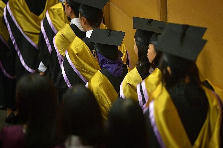 Graduating students at a Nanyang Technological University commencement ceremony. Genes may help determine how long children stay in school, but some of those genes operate at a distance - by influencing parents, researchers have found.