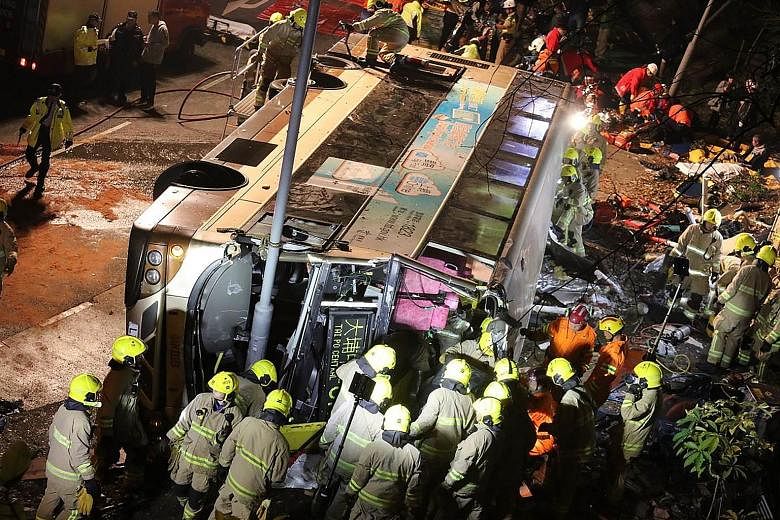 Emergency workers trying to reach people trapped in the double-decker bus that toppled over near the town of Tai Po in Hong Kong yesterday.