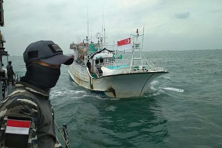 Indonesian navy officers watch over the Sunrise Glory, which was flying the Singapore flag when it was intercepted last week in the Phillip Channel, between Singapore and Batam. Four Taiwanese crewmen on the fishing boat were arrested and more than a