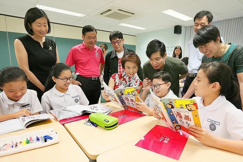 Ms Low Yen Ling (centre) with Kuo Chuan Presbyterian Primary School pupils during their essay-writing lesson yesterday. Looking on are (from left) principal Teo Ching Ling, Dr Chua Chee Lay, Mr Ang Thiam Poh, programme instructor Tan Tiaw Gem, assist