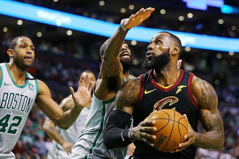 Cavaliers star LeBron James shrugging off the attention of former team-mate Kyrie Irving of the Celtics at the TD Garden on Sunday. The forward imposed his will on a day their Eastern Conference rivals paid tribute to one of their greats, Paul Pierce