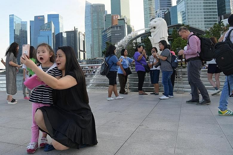 Chinese and other tourists snapping photos at the iconic Merlion Park yesterday, one of the must-visit attractions in Singapore. The surge in visitors from China last year ended Indonesia's 20-year reign as the biggest source of arrivals here.