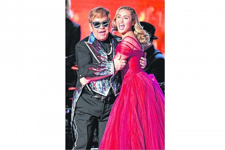 Singer Elton John (left, with singer Miley Cyrus) will not be performing residency shows in Las Vegas on May 18 and 19.