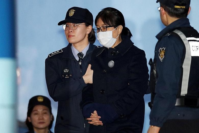 Choi Soon Sil being conveyed to a detention centre yesterday after the Seoul Central District Court found her guilty of abuse of power, bribery and interfering in government business. She had claimed she never sought any personal benefit but attempte