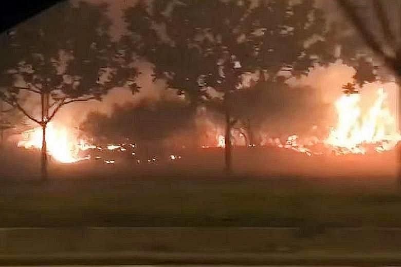 A screengrab from a video sent to online portal Stomp showing a Jurong Island field ablaze, with thick smoke in the air on Tuesday. The SCDF said "intermittent pockets of vegetation" were on fire in an area measuring about four football fields in siz