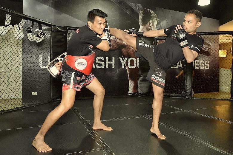 Dejdamrong Sor Amnuaysirichoke (right), whom One Championship has signed for its inaugural kickboxing competition, sparring with muay thai star Namsaknoi Yudthagarngamtorn in May 2015. One aims to have the same pay structure for both mixed martial ar