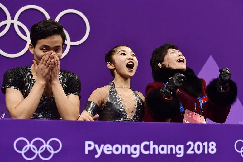 Top: Leaders Sui Wenjing and Han Cong from China showing their sizzling chemistry in the pairs skating short programme at the Gangneung Ice Arena yesterday. Above: North Korea's Kim Ju Sik (left) and Ryom Tae Ok can hardly believe their personal-best