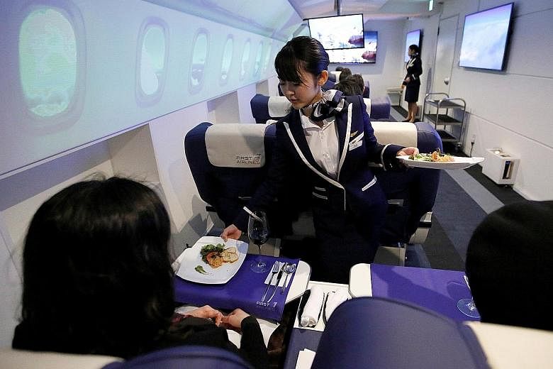 An employee, dressed as a flight attendant, serving appetisers to guests on First Airlines, a virtual first-and business-class airline experience facility in Tokyo. The Japanese company is offering trips to Paris on flights that never leave the groun