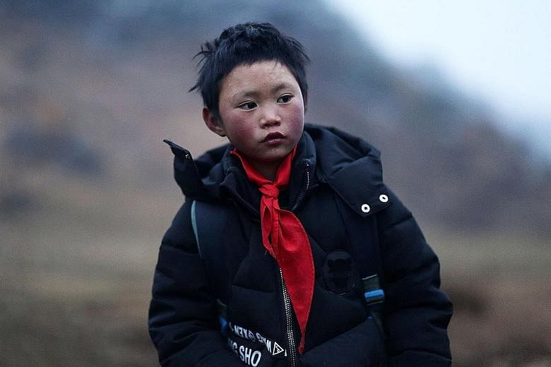 Far left: Wang Fuman with his hair and eyebrows encrusted with ice after a freezing, hour-long trek to school last month. Left: The eight-year-old is hoping for a Chinese New Year reunion with his mother, who walked out on her family two years ago.