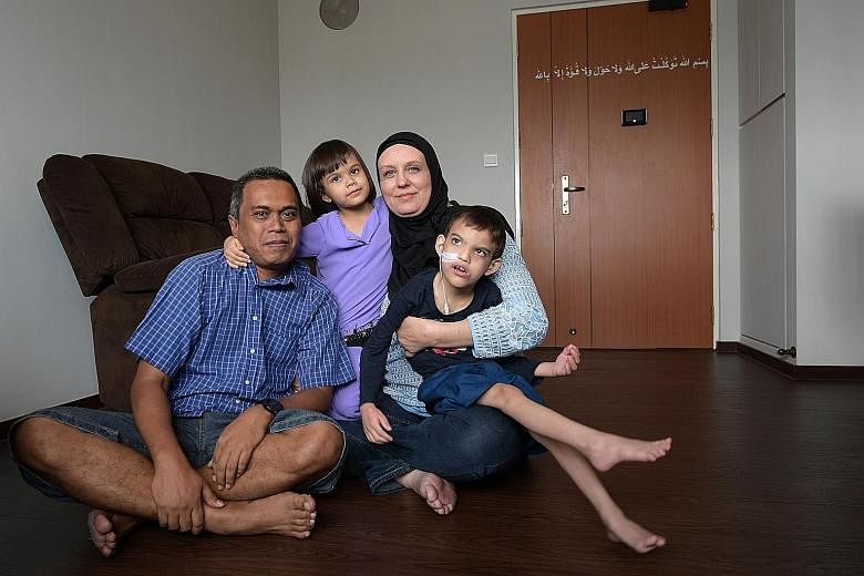 Mr Mohd Aszrin Ahmad is now a proud owner of a three-room Housing Board flat in Sembawang. He is seen here with his wife Tasha Ahrens, 42, and their children, Dean Joaquim, seven, and Sara Elizabeth, four.