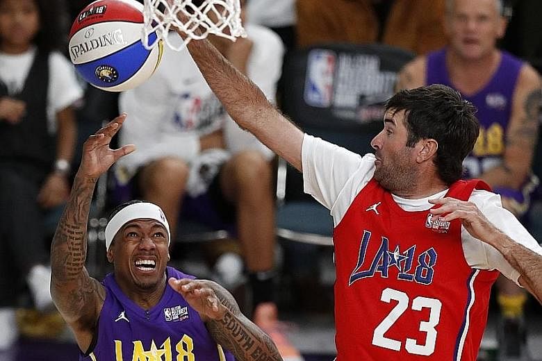 Golfer Bubba Watson blocking a shot by singer Nick Cannon during the NBA All-Star Celebrity Game in Los Angeles on Friday.