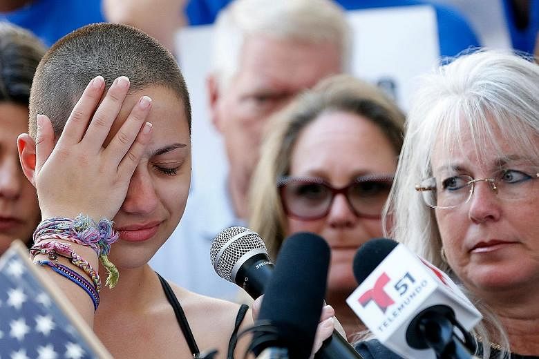 Above: Ms Emma Gonzalez, an 18-year-old student at Marjory Stoneman Douglas High School, where Wednesday's shooting took place, giving a speech at a rally for gun control in Fort Lauderdale, Florida, on Saturday. Left: Protesters at the rally in Flor