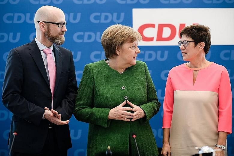 German Chancellor Angela Merkel with her close confidante Annegret Kramp-Karrenbauer at the CDU's headquarters in Berlin yesterday. The latter is strongly tipped to succeed Dr Merkel eventually.