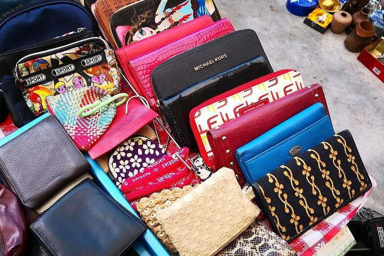 Some of the items karung guni collectors have picked up include spotless wallets from brands such as Michael Kors. Movers from waste disposal firm Junk To Clear removing an underused fitness machine from an apartment.