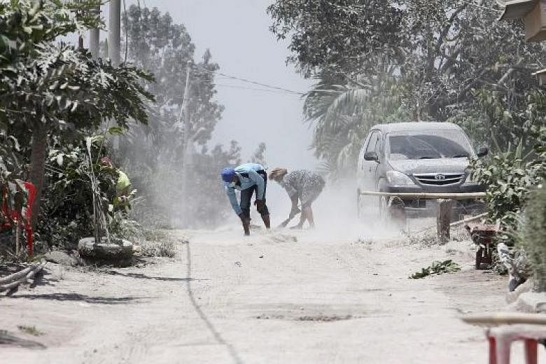Volcanic ash being cleared from the street in Karo, North Sumatra, yesterday after Mount Sinabung spewed thick ash and smoke across the area the day before. The heightened activity covered hundreds of houses outside the 7km danger zone in volcanic as