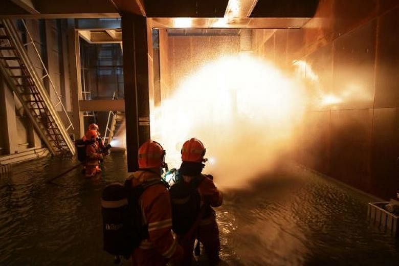 SCDF Marine Command personnel simulate putting out an engine block fire on board the Orca. Such training "gives our firefighters a very realistic environment to practise in", said West Coast Marine Fire Station commander Neo Jia Qi.
