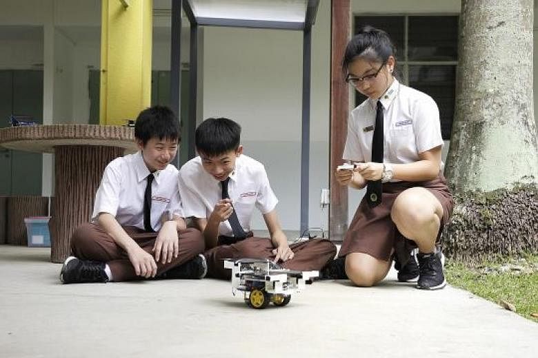 Bukit View Secondary School students (from left) Marvyn Chia 15, Yeo Swe Hon, 15, and Wong Shi Ya, 16, operating a "solar car". The school's Joules (Junior Outstanding Leaders in Environment for Sustainability) Smart Centre was launched by Environmen