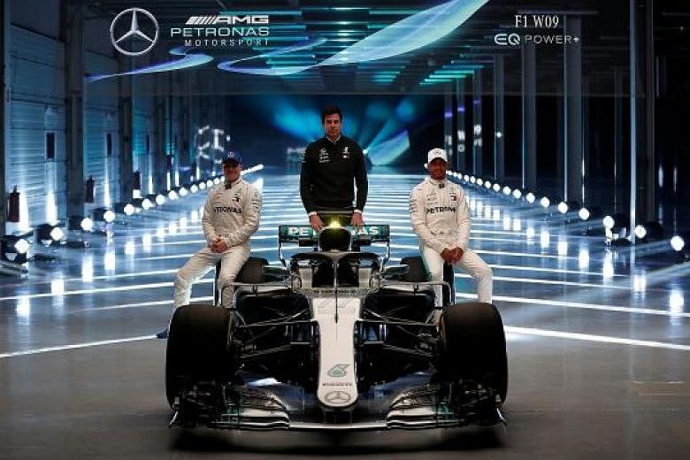 Mercedes' defending champion Lewis Hamilton (right), Valtteri Bottas and executive director Toto Wolff posing with their new "diva" - the W09 - at Silverstone.