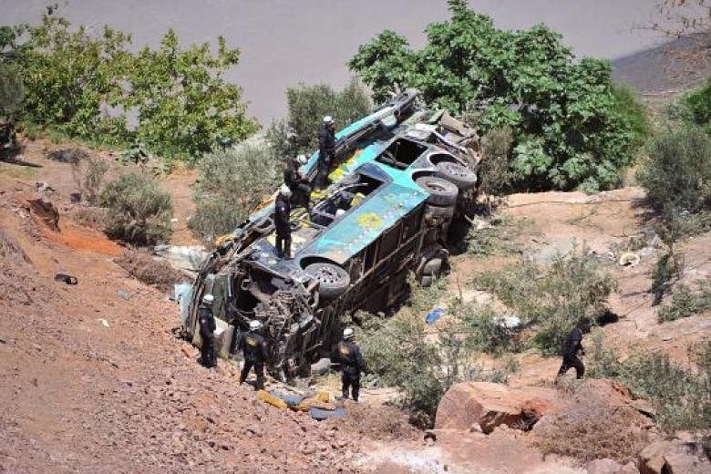 Rescue workers at the scene of the crash site in Arequipa. The double-decker bus had veered off a mountain road and plunged into a ravine. 
