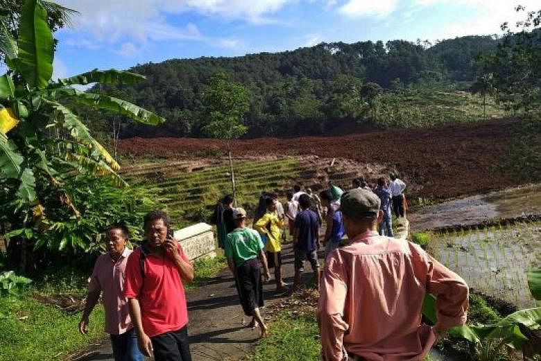 A handout photo from Indonesia's disaster mitigation agency shows residents gathering near the landslide site in Brebes yesterday. The victims were buried under an avalanche of mud and rock.