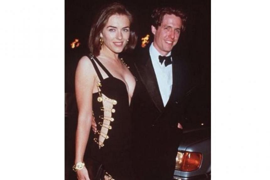 Jennifer Lawrence's black dress brings to mind a similar gown that actress Elizabeth Hurley wore in 1994 (above, with actor Hugh Grant) - both are by Versace and feature a plunging neckline and a high slit. 