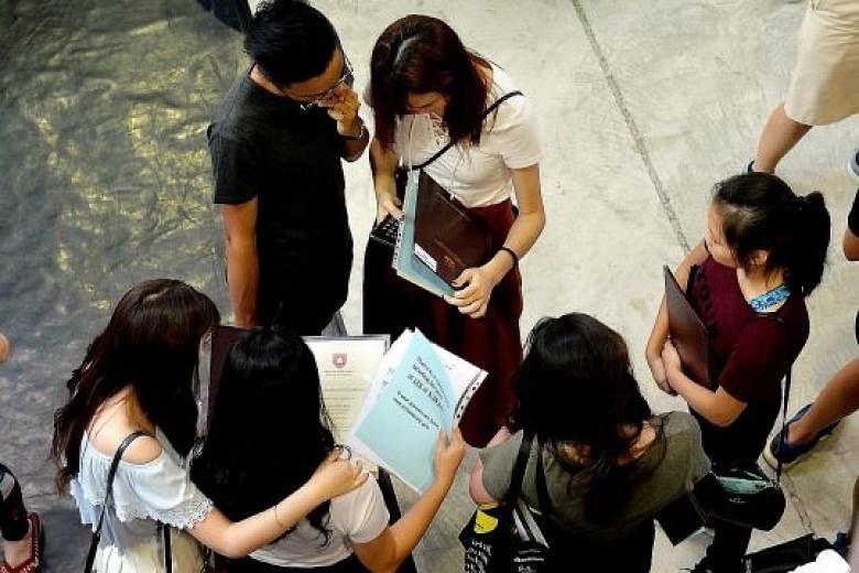Students checking their A-level result slips yesterday in Nanyang Junior College, one of the four schools affected by the theft of exam scripts for Chemistry Paper 3, which carries 35 per cent of the marks for the subject. The scripts were being deli