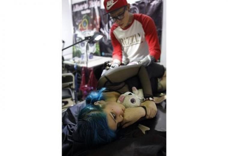 A tattoo artist applying a tattoo during the second Tattoos Convention in Mexico City this month. Teenagers need to know about the health, social and practical implications of getting a tattoo.