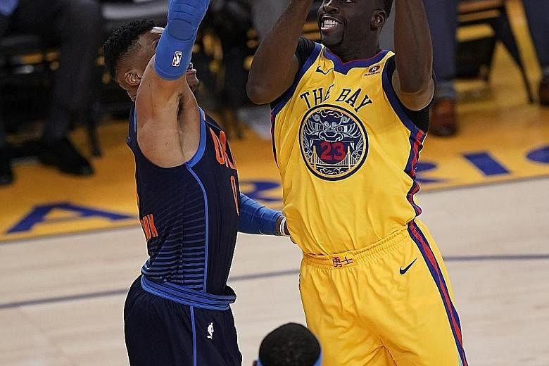 Golden State's Draymond Green going to the basket under pressure from Oklahoma City guard Russell Westbrook. The Warriors forward notched his 2,000th career assist in a 112-80 win for the champions.
