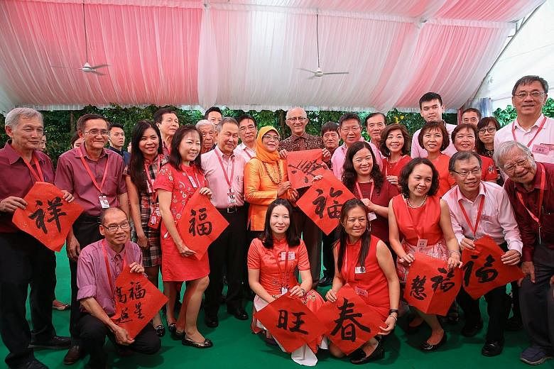 President Halimah Yacob and her husband, Mr Mohamed Abdullah Alhabshee, taking a group photograph with members of the Chinese Calligraphy Society of Singapore at the Chinese New Year Garden Party yesterday. Prime Minister Lee Hsien Loong stopping to 