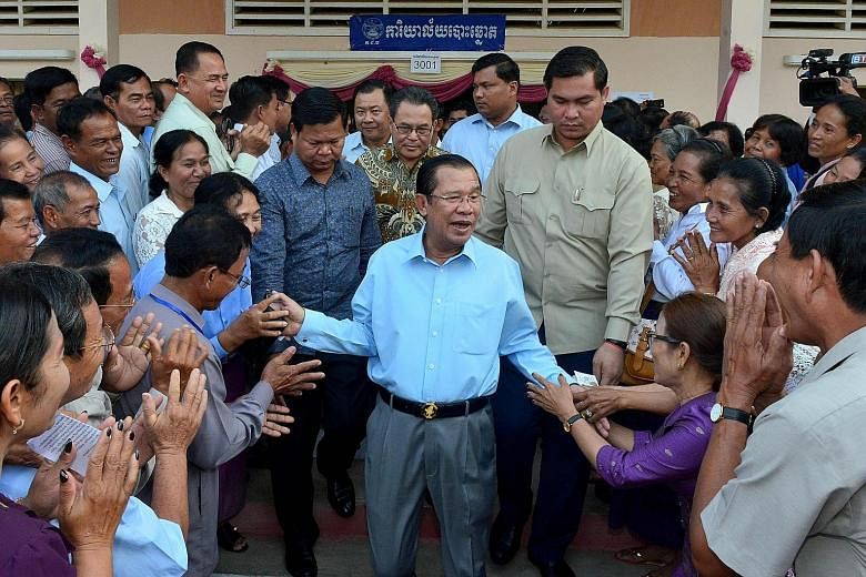 Prime Minister Hun Sen surrounded by commune councillors at a polling station in Cambodia's Kandal province yesterday. The election for the 62-seat Senate arouses little public interest because the Upper House is seen as a rubber-stamp body and candi