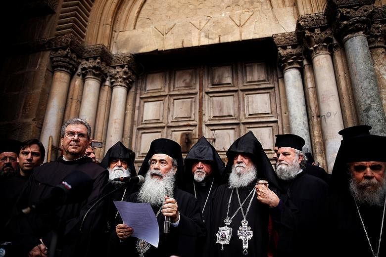 Greek Orthodox Patriarch of Jerusalem Theophilos III speaking at a news conference in front of the closed doors of Jerusalem's Church of the Holy Sepulchre on Sunday.