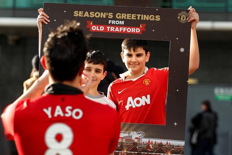 Manchester United fans in good cheer outside Old Trafford before the game against Burnley on Boxing Day last year. Having a winter break in February will be a compromise between clubs' demands for a rest in mid-season and fans who insist on having th