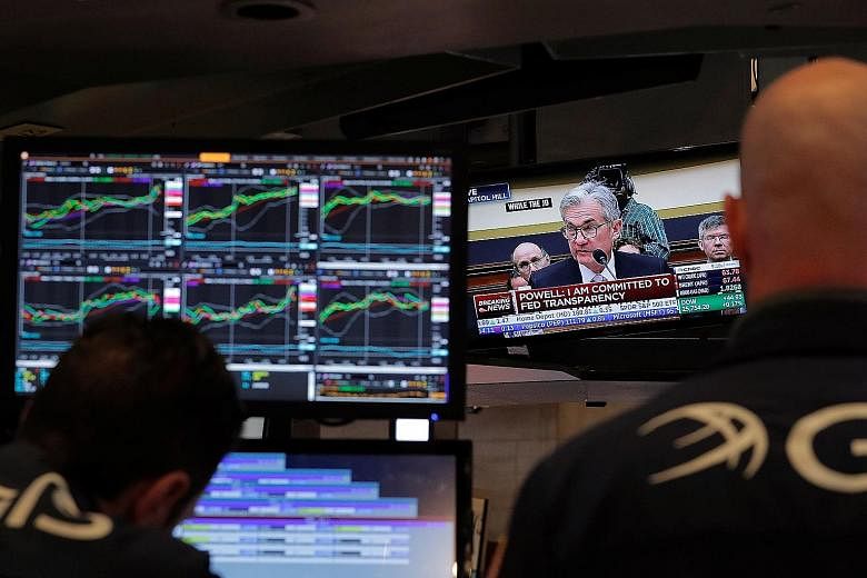 New York Stock Exchange traders watching a TV broadcast of Federal Reserve chairman Jerome Powell testifying before the US House of Representatives' Financial Services Committee on Tuesday.