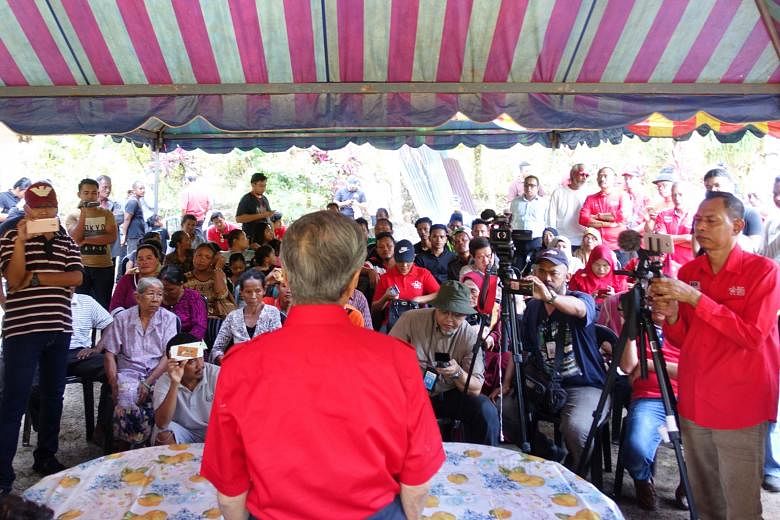 Opposition leader Mahathir Mohamad speaking to indigenous people during a visit on Wednesday to Kampung Gumum, near the Felda Chini 2 settlement in the Malaysian state of Pahang.