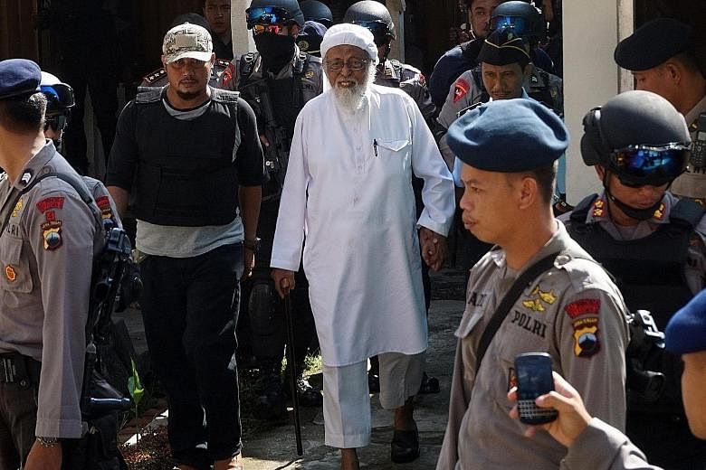 Indonesian radical Muslim cleric Abu Bakar Bashir (centre) being escorted by anti-terror police as he arrived for his appeal trial in Cilacap, Central Java, in 2016. Bashir was sentenced to 15 years in jail and was at first housed in isolation in a m