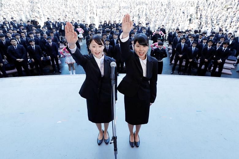 Japanese college students publicly declaring they would do their best to find work during a job-hunting pep rally held to boost their morale, at an outdoor theatre in Tokyo.