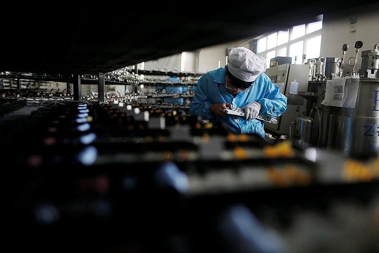 A reshuffle of financial regulatory chiefs may see An electronics factory in Qingdao, Shandong province. Analysts say China is likely to set its growth target at around 6.5 per cent.