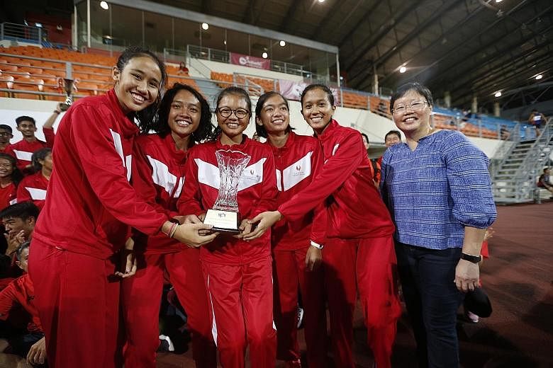 SSP's A Division girls' 4x100m quartet and ST sports editor Lee Yulin posing with the Tay Cheng Khoon Memorial Trophy.