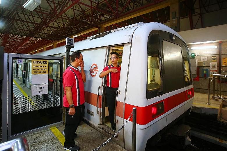 SMRT train captain Mohamad Rezza Abdul Malek (right) taking over from a colleague during yesterday's trial. The 31-year-old, who recently welcomed a baby girl but came back on his day off to help out with the testing, said: "Every day is a learning p
