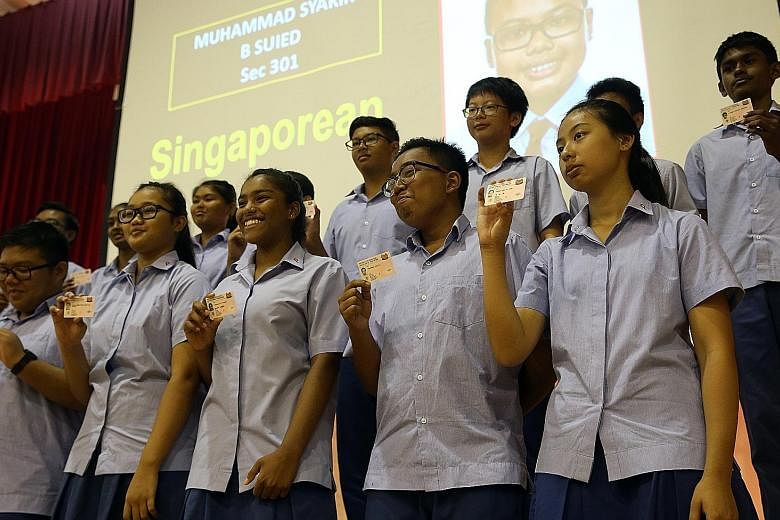 More than 70 Secondary 3 students from Ping Yi Secondary School receiving their NRICs at a presentation ceremony at their school yesterday. Before the ceremony, the students took part in a reflection session on what it means to be Singaporean.